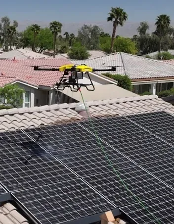 Cleaning drone hovering above rooftop solar panels
