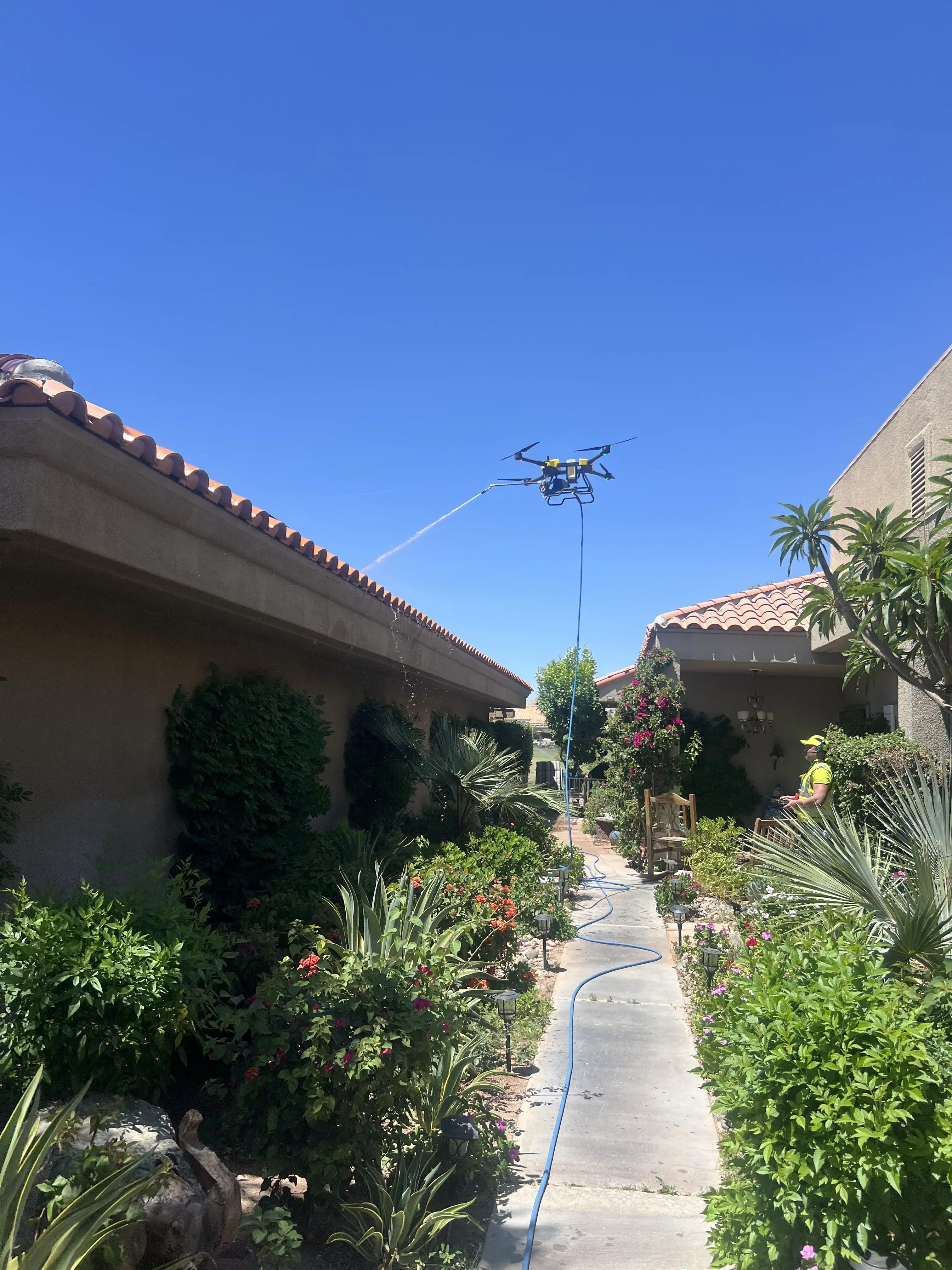 DronePower1 drone hovering over a narrow courtyard between residential buildings