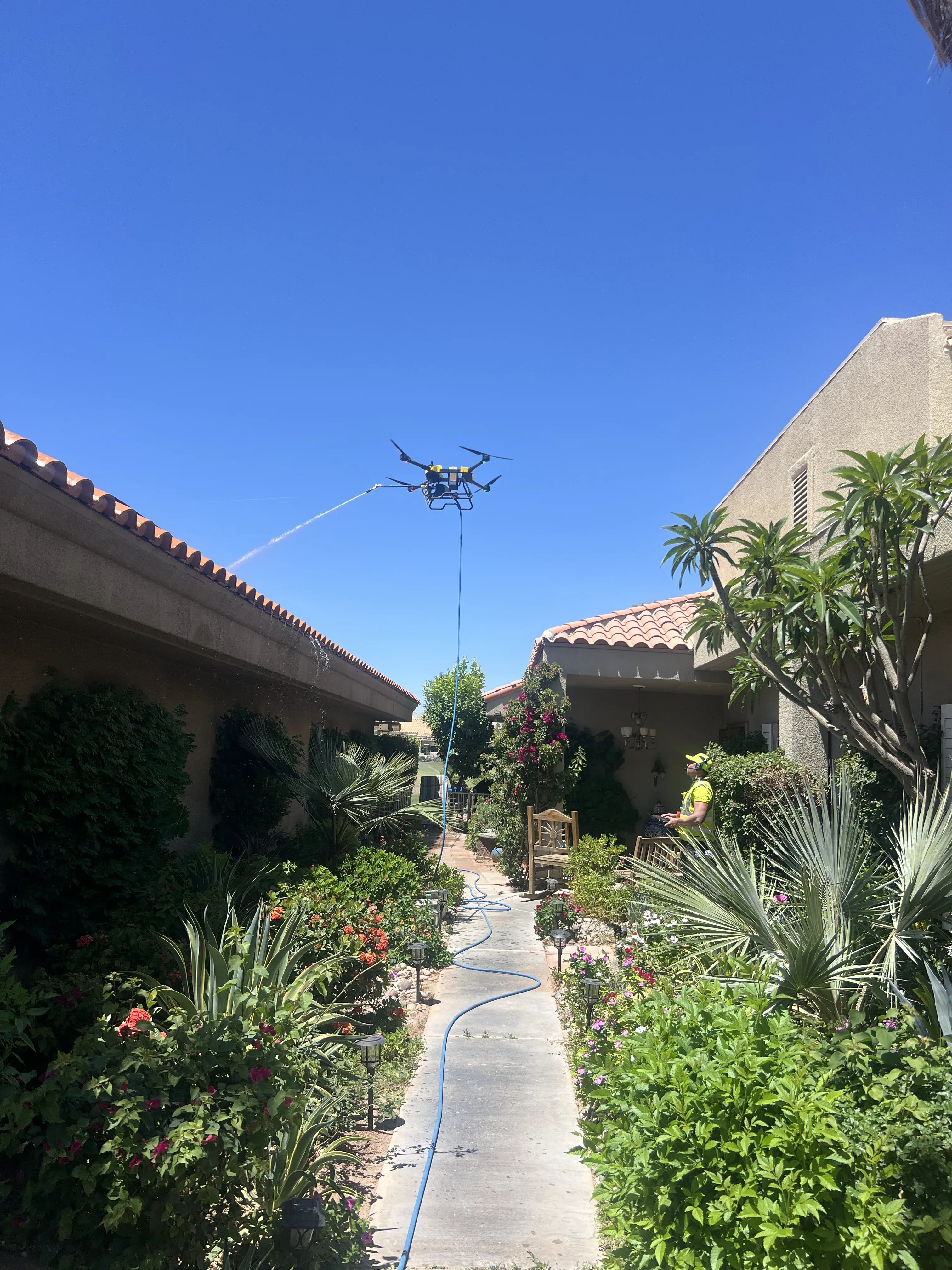 DronePower1 drone centered above a residential courtyard during a cleaning pass