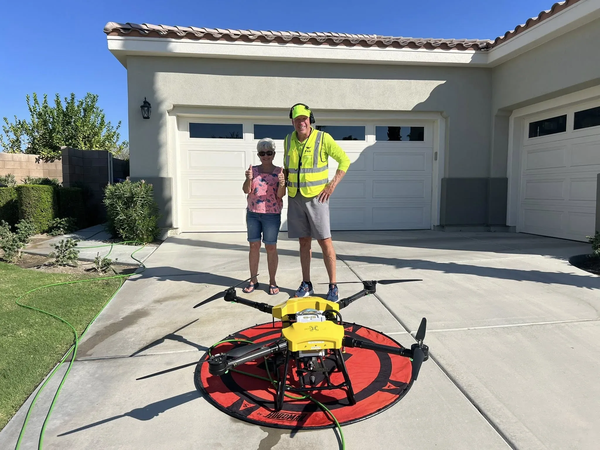Homeowner and DronePower1 operator standing beside the drone rig staged in the driveway
