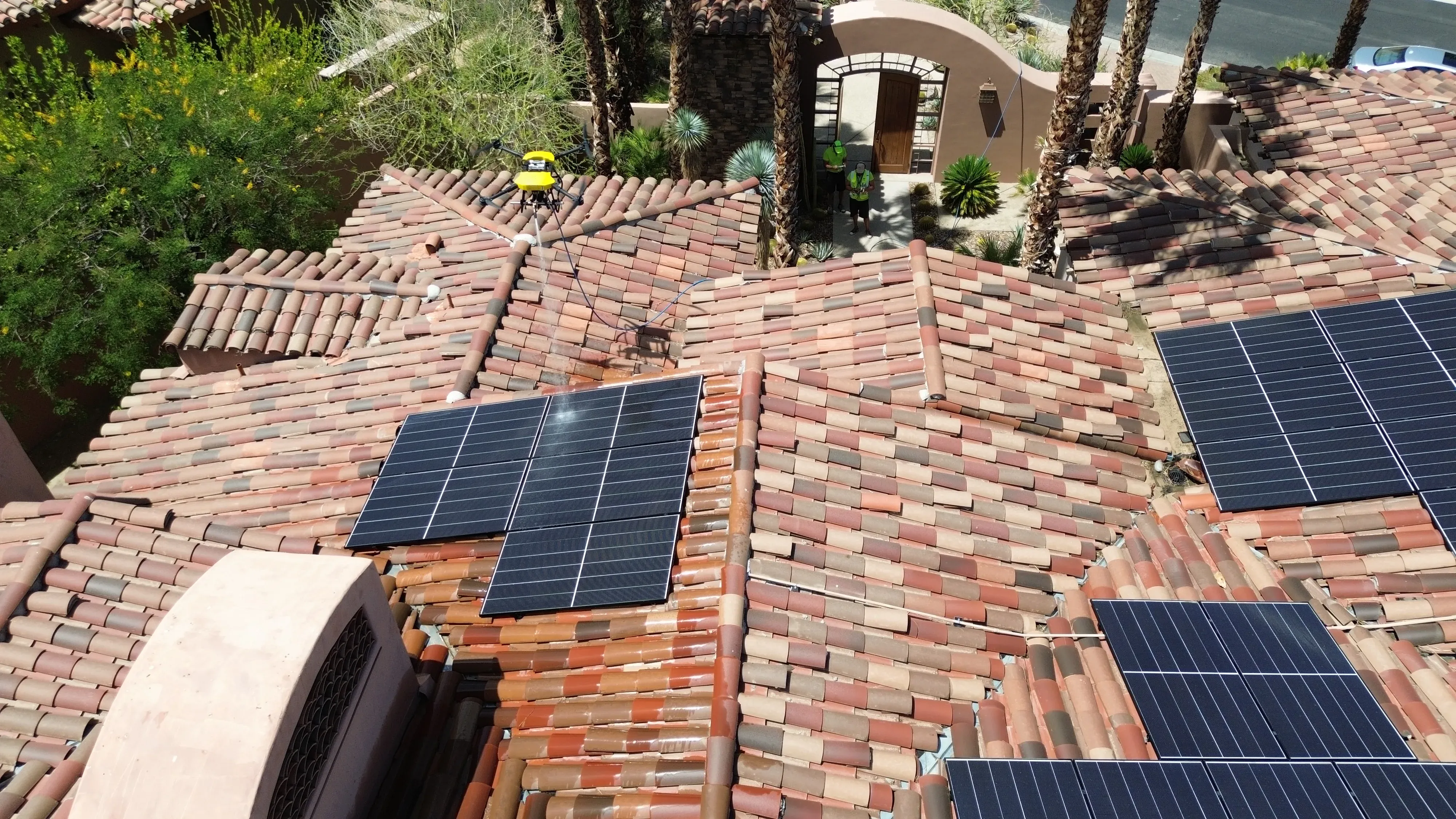 High-angle aerial view of a rooftop with a solar panel array laid across the surface