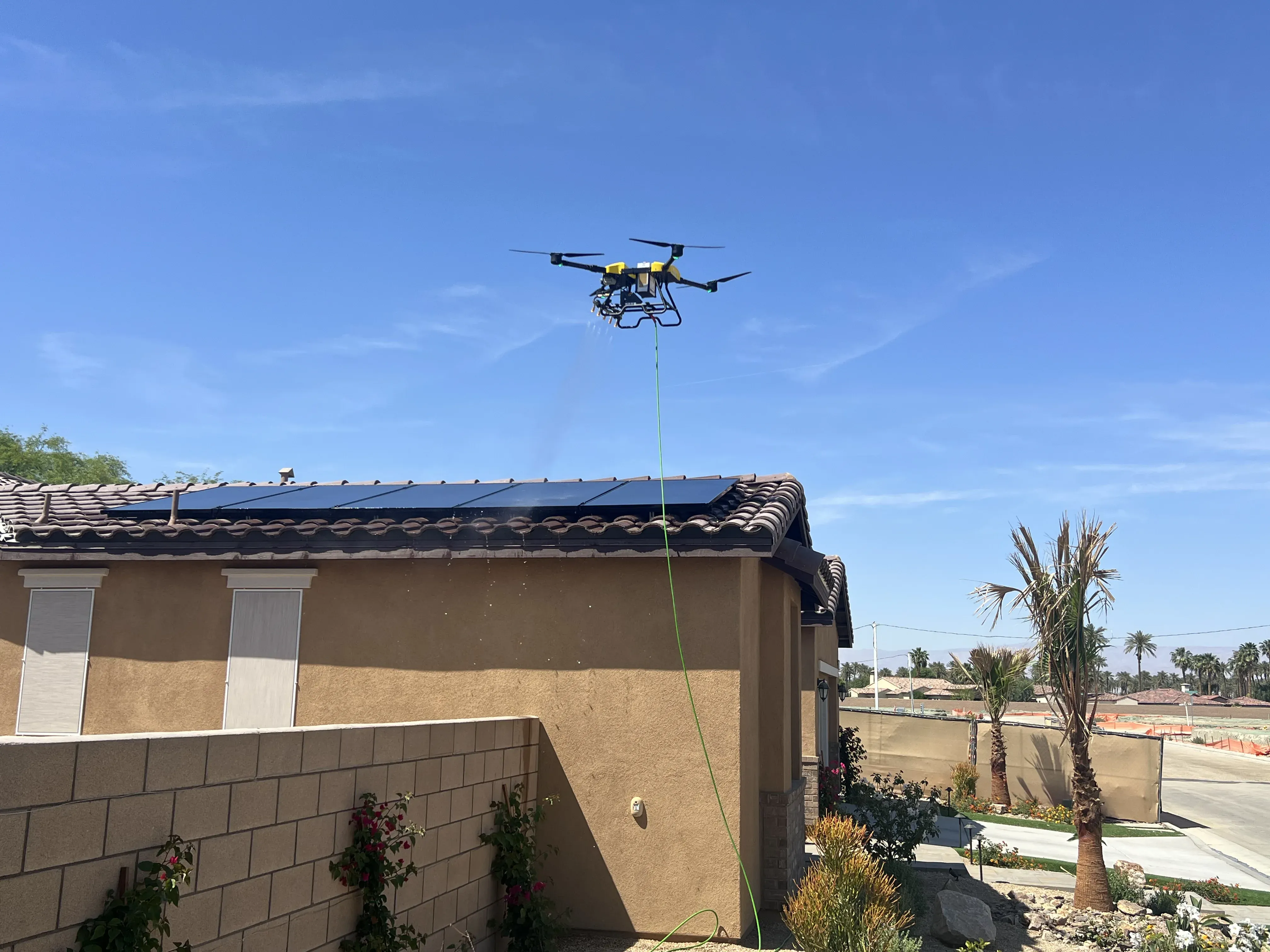 Aerial view of a DronePower1 drone hovering above a rooftop solar array