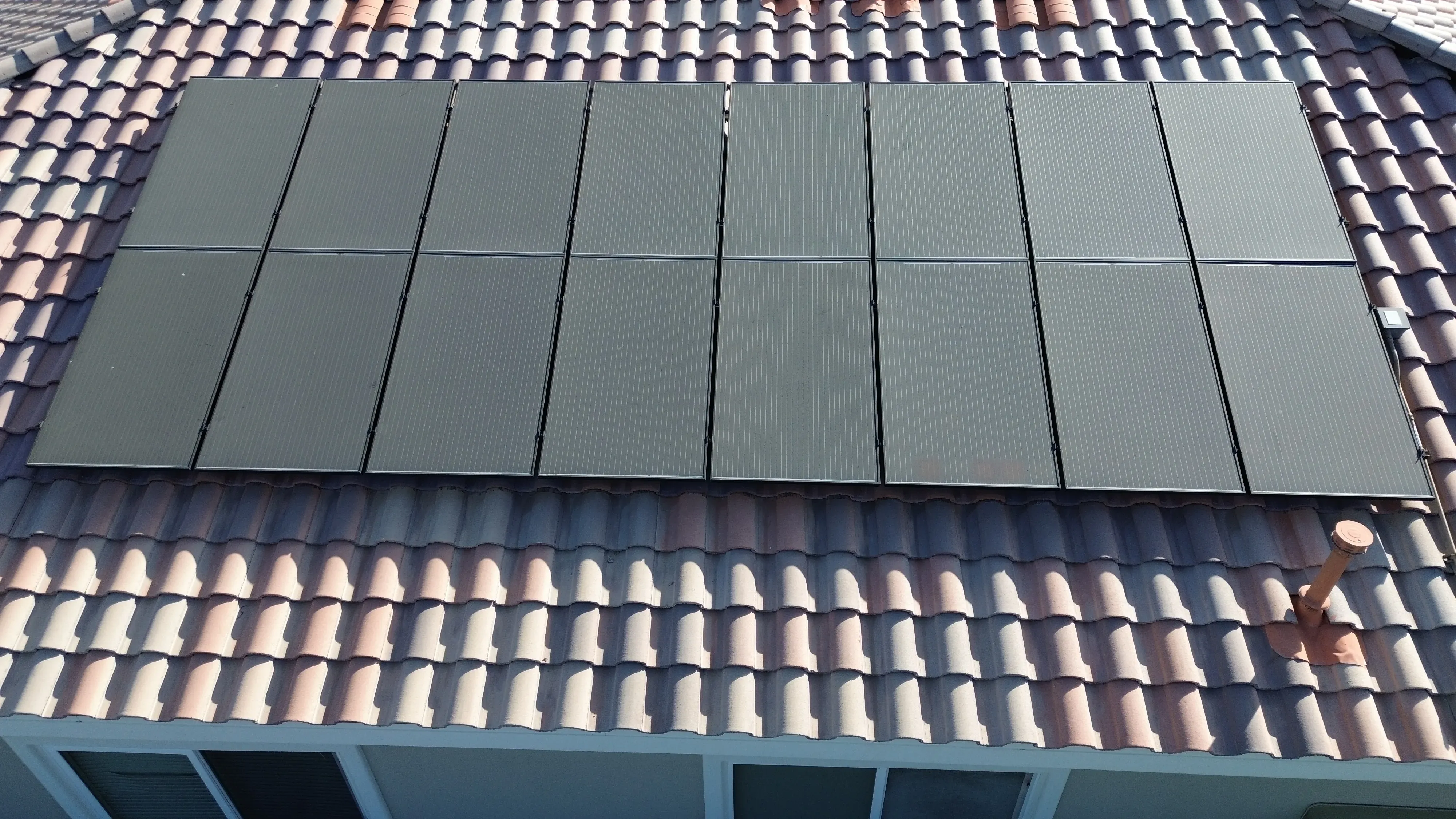 Close-up overhead view of solar panels laid across a tiled roof