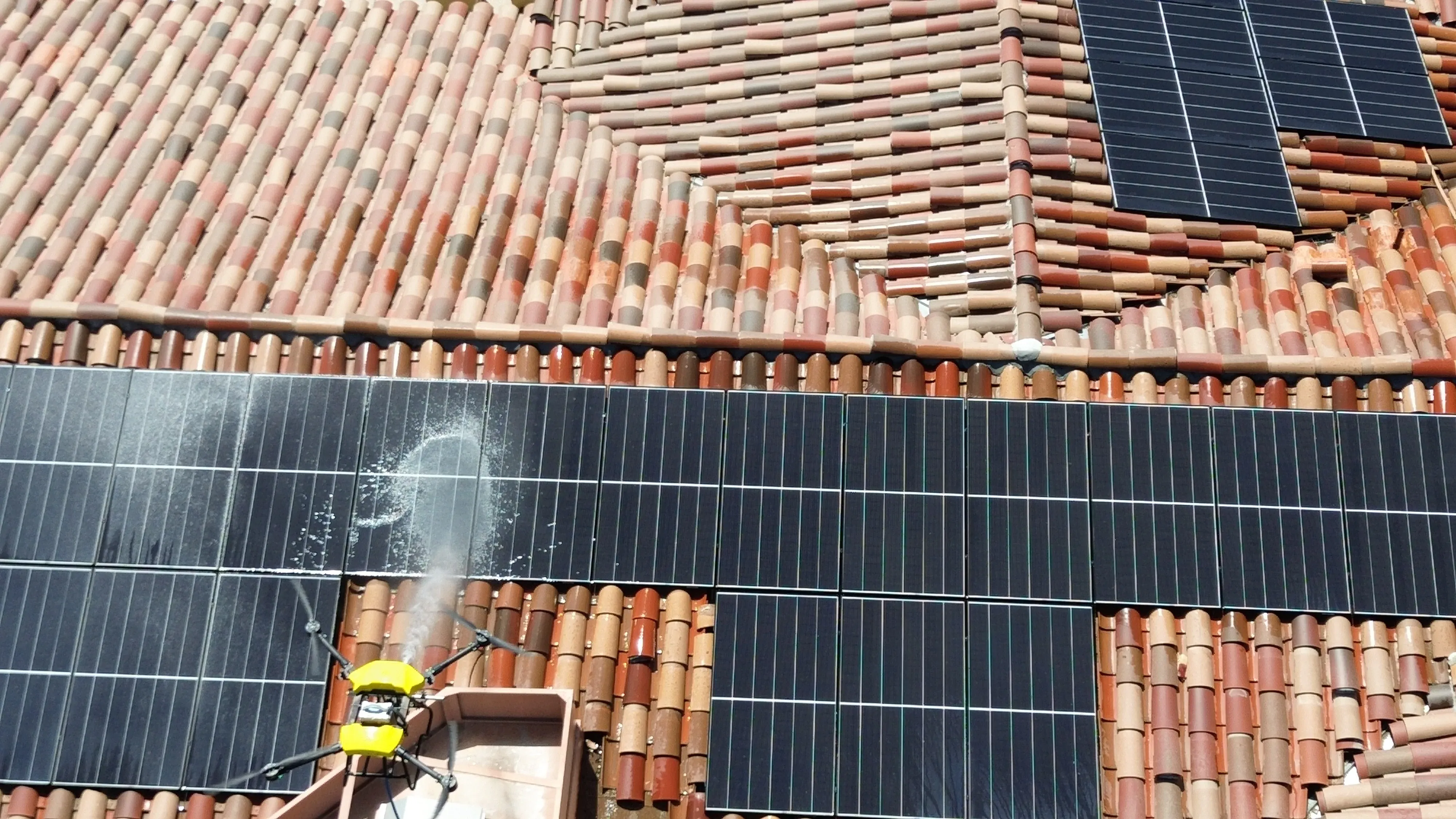 Roof-level process view of solar panels during a DronePower1 cleaning pass
