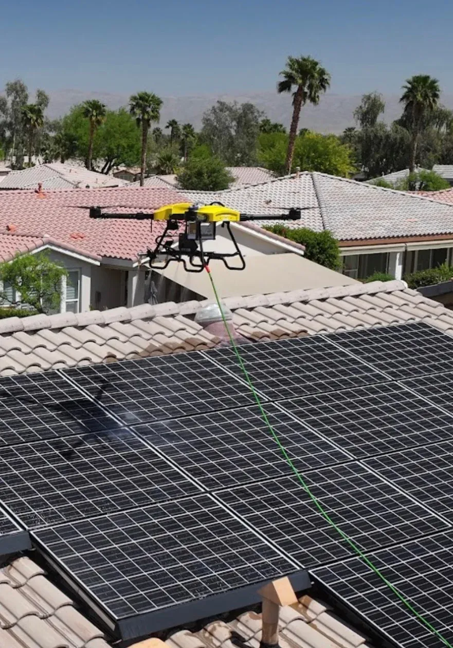 DronePower1 drone hovering over a rooftop solar array with palm trees in the background