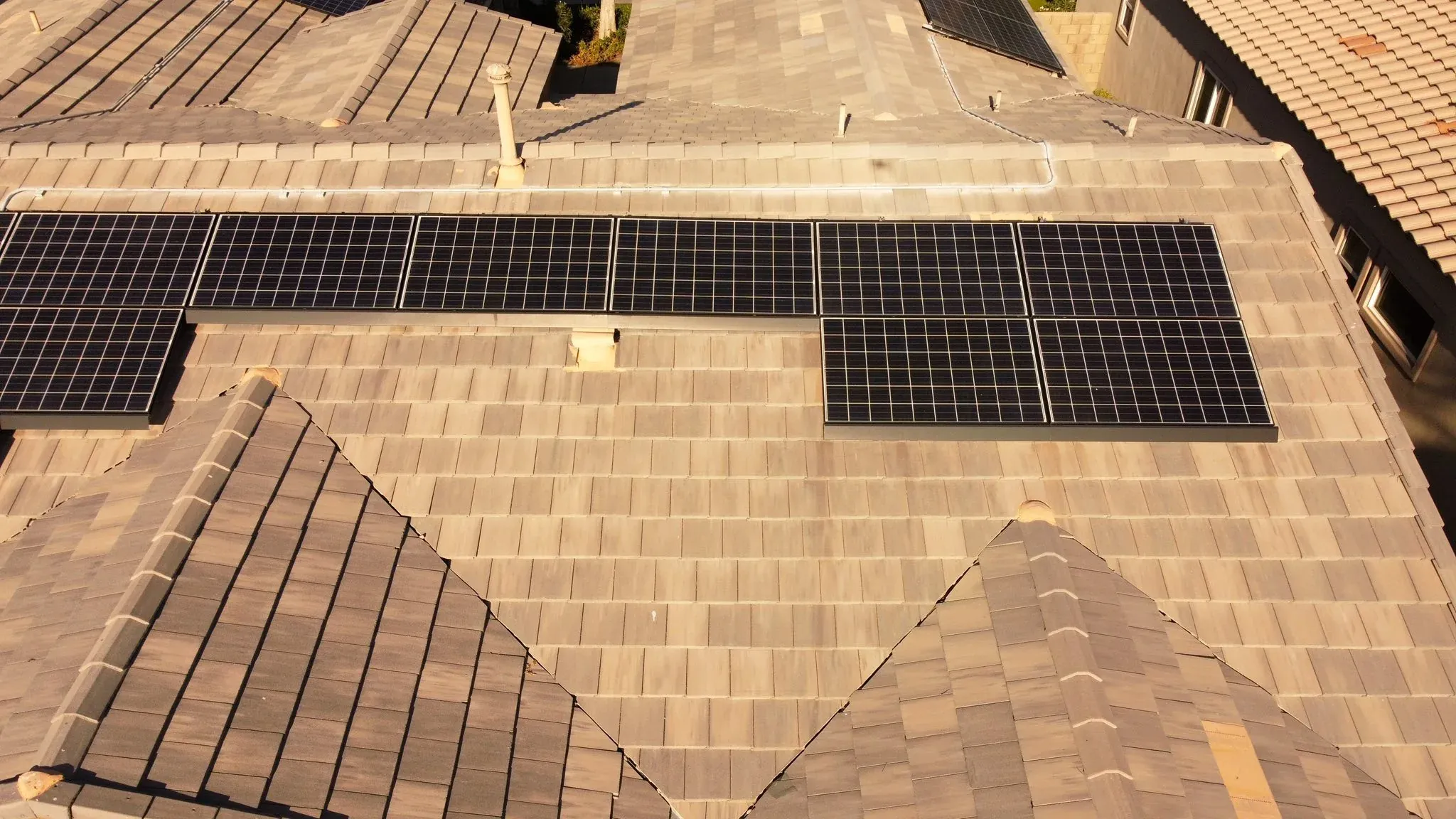 Aerial view of a roof with a solar array under a clear sky