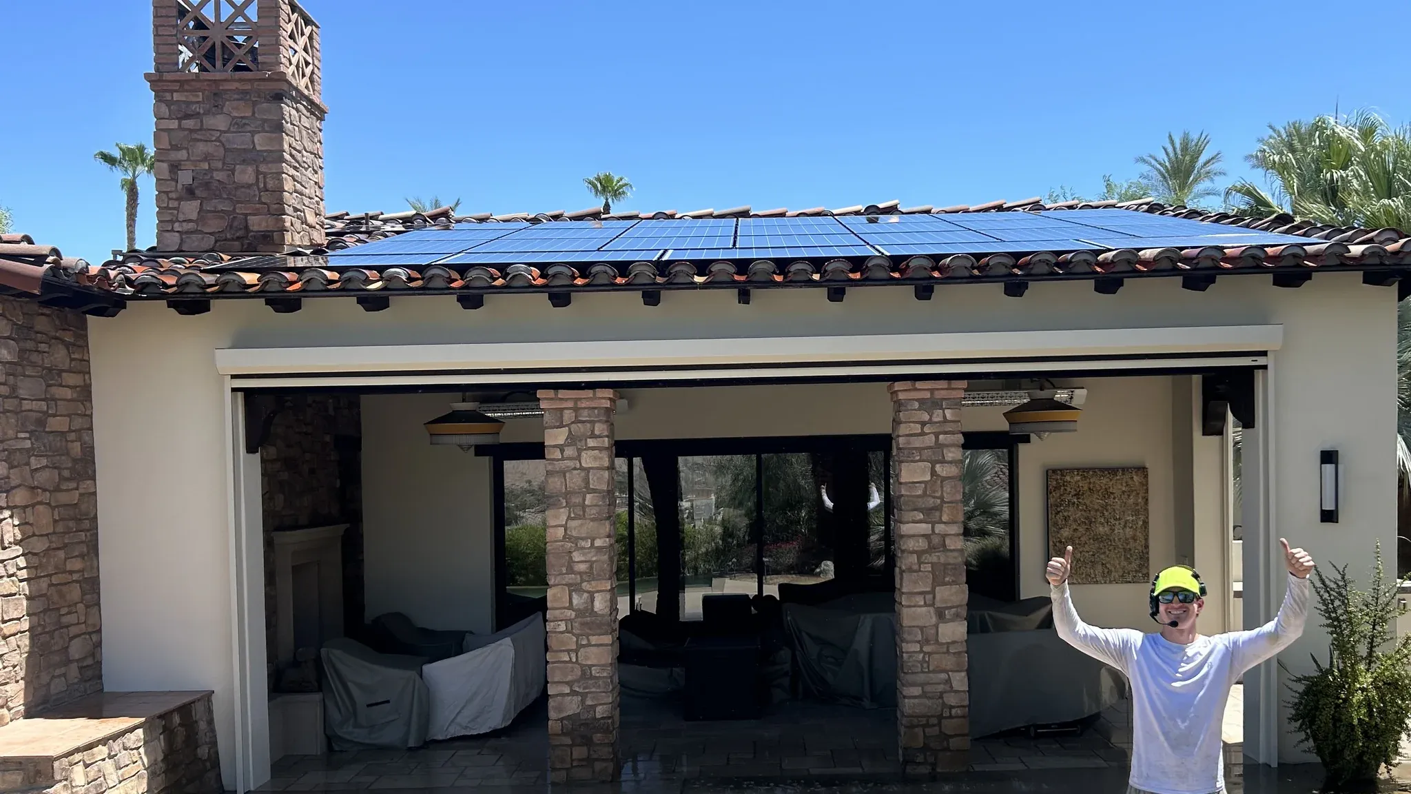 The same Coachella Valley tile-roof solar array after a DronePower1 drone cleaning, every panel deep blue and glare-free with the operator celebrating on the wet patio below